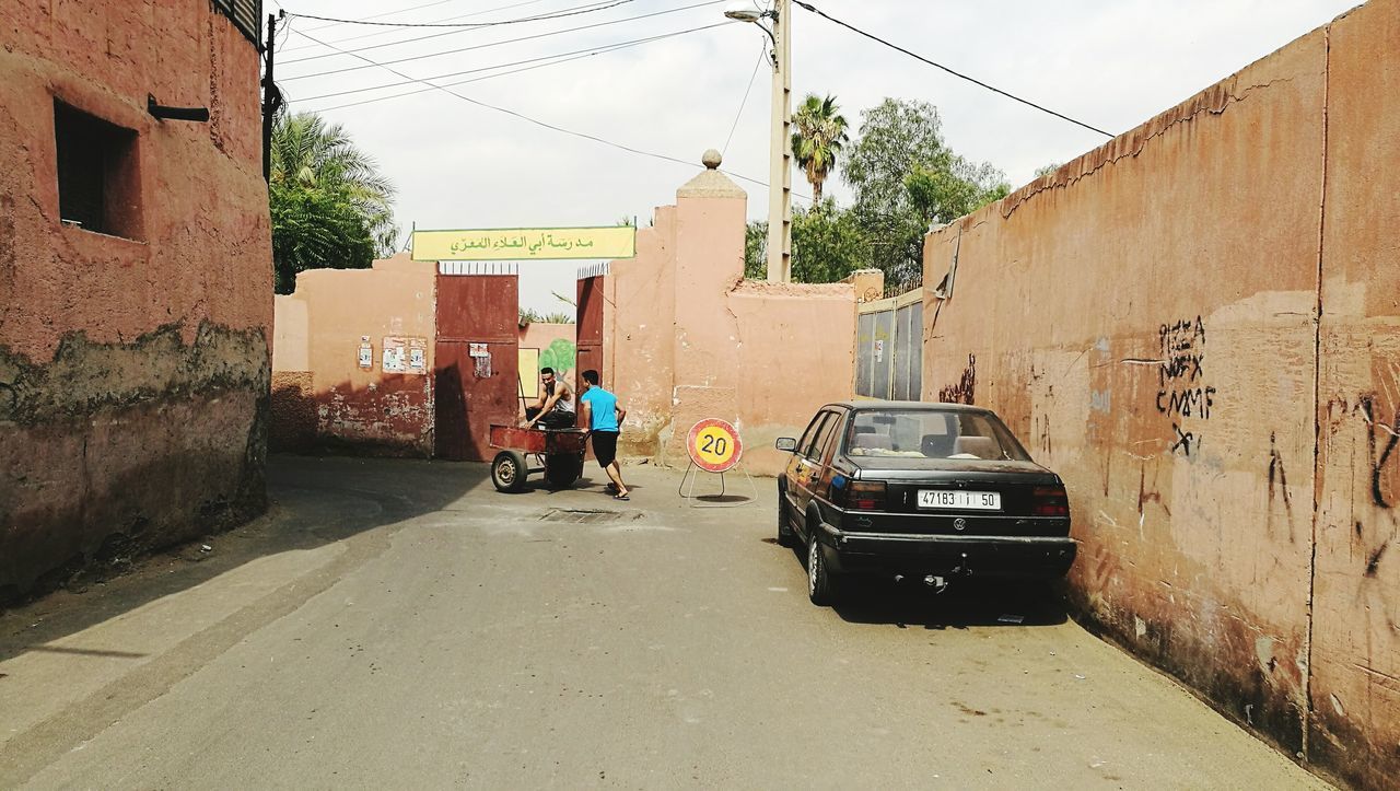 PEOPLE WORKING ON STREET AMIDST BUILDINGS