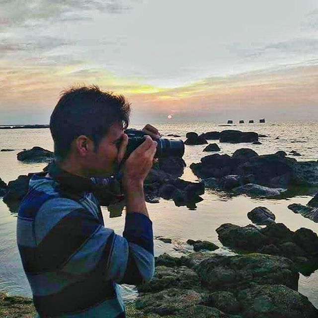 sunset, sea, water, lifestyles, sky, leisure activity, beach, cloud - sky, person, shore, scenics, beauty in nature, horizon over water, rock - object, standing, young men, nature, vacations