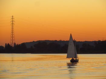 Boats in calm sea at sunset