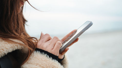 Midsection of woman using mobile phone