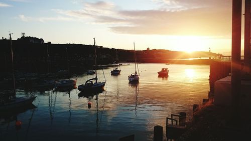 Boats in calm sea at sunset