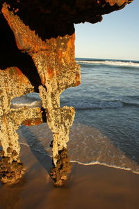 Close-up of water on beach against sky