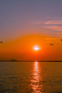 Scenic view of sea against orange sky