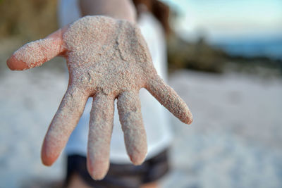 Close-up of hand with sand