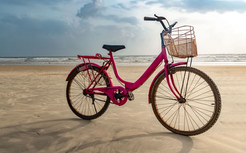 Bicycles on beach against sky