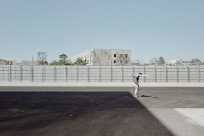 Man standing by built structure against clear sky