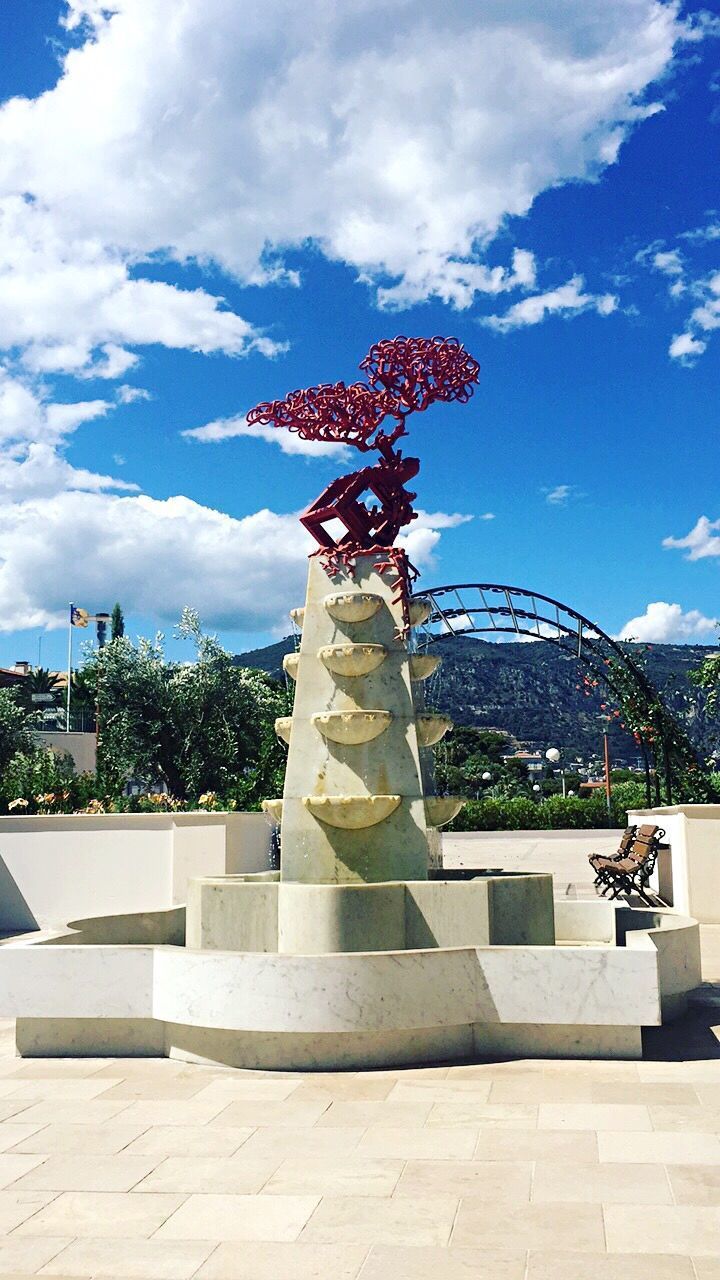 STATUE OF TREE WITH BUILDING IN BACKGROUND