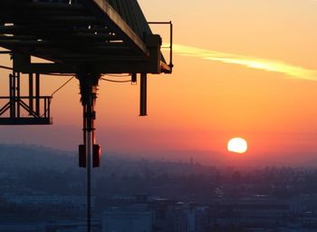 Silhouette city against sky at sunset