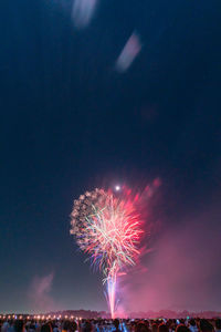 Low angle view of firework display at night