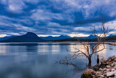 Scenic view of lake by mountains against sky