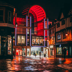 People walking on illuminated city at night