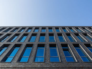 Low angle view of facade of building against blue sky