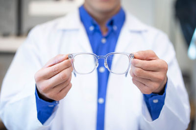 Midsection of doctor holding dentures