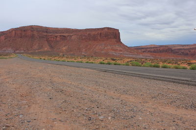 Scenic view of road leading towards mountains against sky