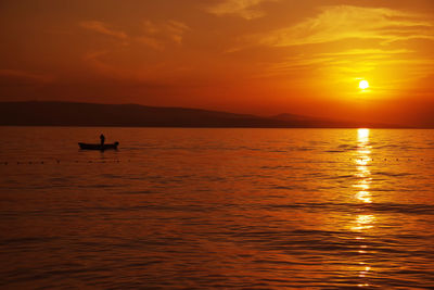 Scenic view of sea against orange sky