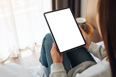 Midsection of woman using digital tablet