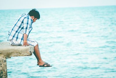 Side view of man sitting in sea