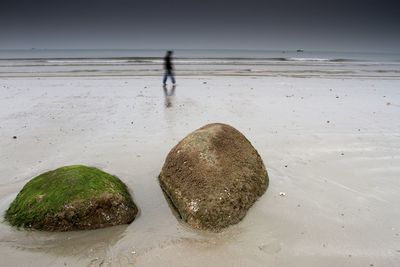 Scenic view of rocks on beach against sky