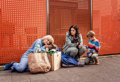 Family of ukrainian refugees with senior, children and cat fleeing from ukraine waiting for help 