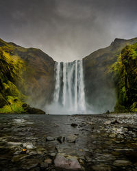 Scenic view of waterfall against sky