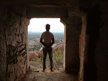 Rear view of man standing at archway