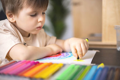 Close-up of boy drawing on book