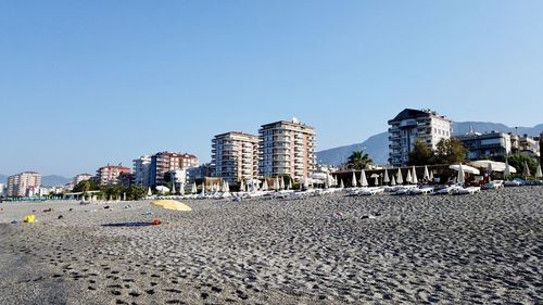 Buildings in city against clear blue sky