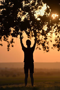 Closeup portrait young man praying hands up against sunset