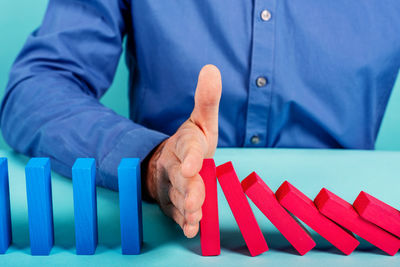 Midsection of man holding umbrella on table