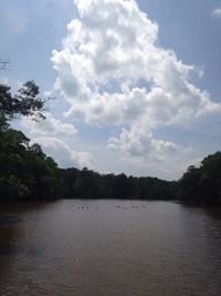 Scenic view of river against cloudy sky