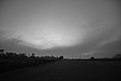 Road amidst field against sky