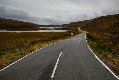 Road by mountain against sky