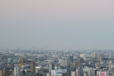 Aerial view of buildings in city against sky