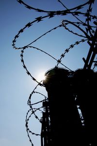 Low angle view of barbed wire against sky