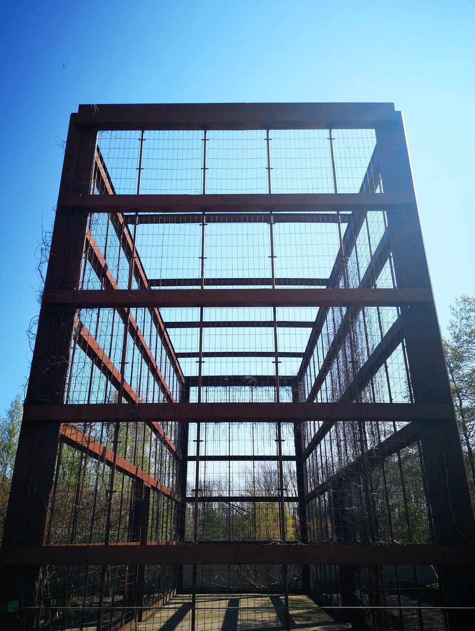 LOW ANGLE VIEW OF GLASS BUILDING AGAINST BLUE SKY