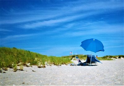 People on beach against blue sky