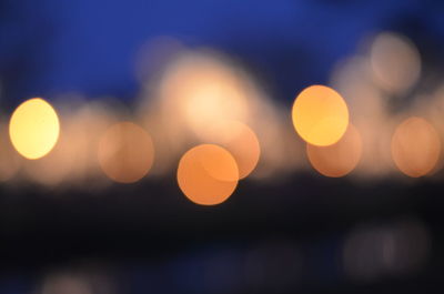 Defocused lights against sky at night