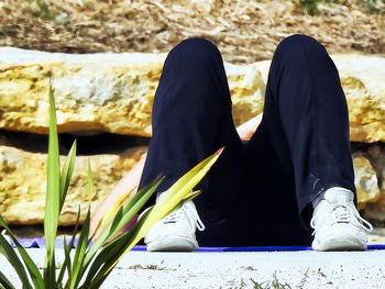 Low section of person sitting on land