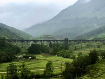 Scenic view of bridge over mountains against sky