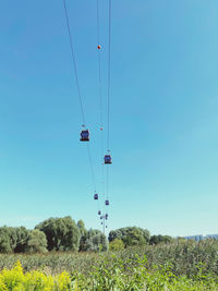 Low angle view of overhead cable car against clear blue sky