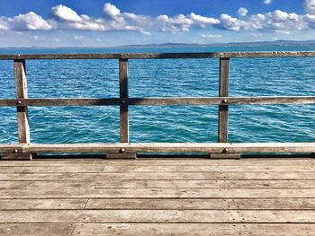 Pier over sea against blue sky