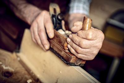 Midsection of man working on wood