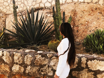 Side view of woman standing against wall