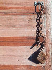 Close-up of chain hanging on wood
