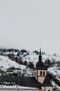 Church amidst buildings against sky during winter