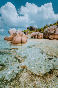 Rocks on sea shore against sky