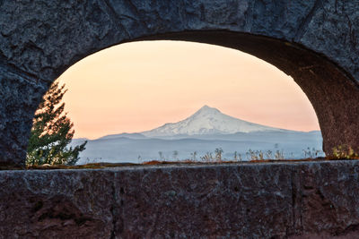 Scenic view of mountains against sky seen through arch window