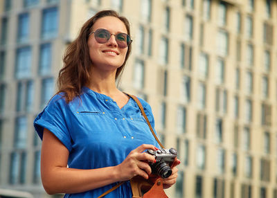 Young woman photographing with camera