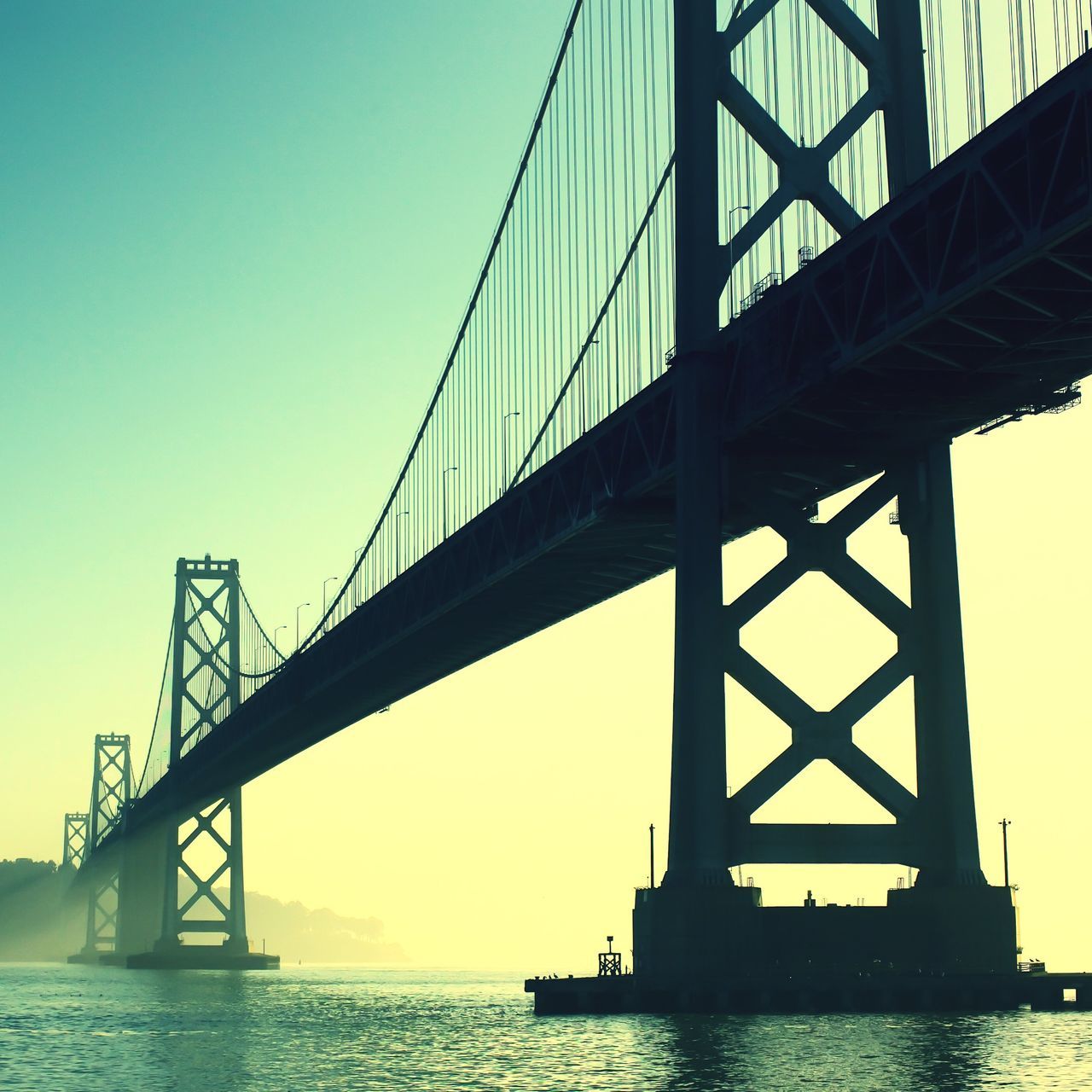 connection, engineering, bridge - man made structure, suspension bridge, built structure, water, transportation, architecture, sea, bridge, low angle view, waterfront, sky, river, travel destinations, clear sky, long, blue, silhouette, travel