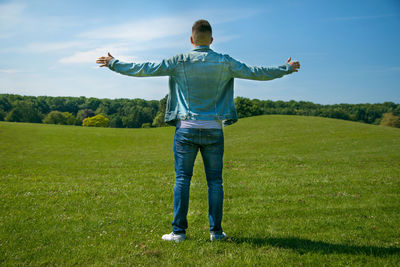 Man in denim and arms wide open feel freedom in park